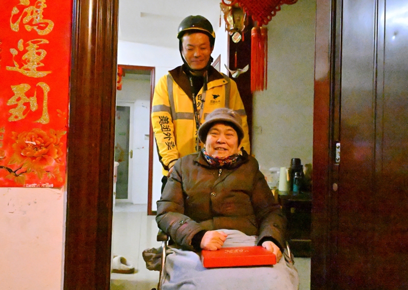 (图为外卖小哥上门为老人服务)