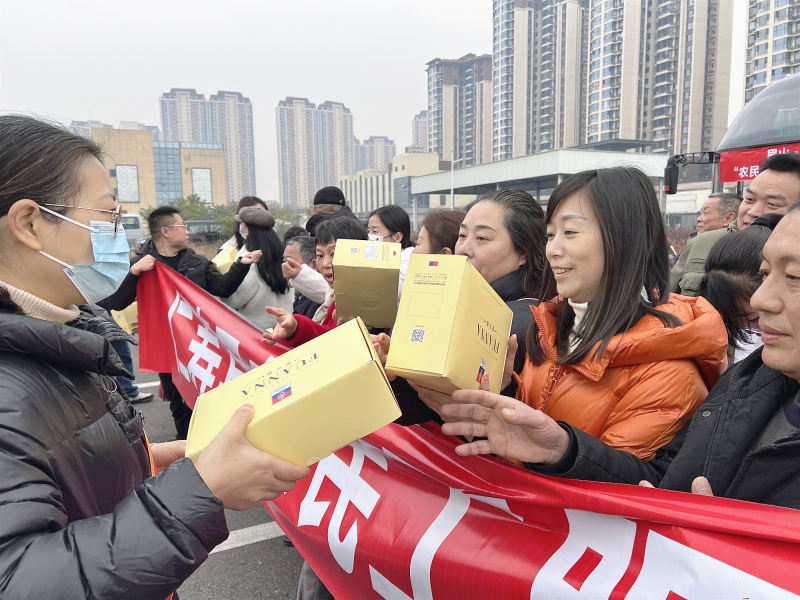 图为工作人员为回家务工人员发放暖心礼品