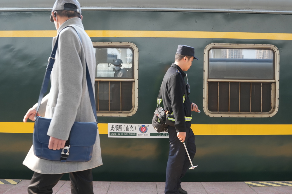 1月13日，中国铁路成都局集团有限公司成都车辆段职工金峰正在为该段首趟春运列车——K4618进行发车前“体检”（肖寒 摄）（2）