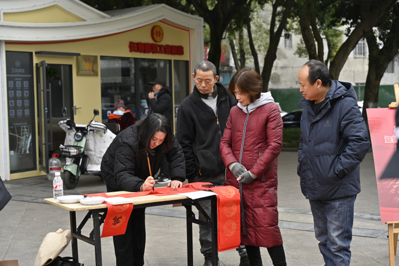 图为当地职工群众观看书法家写春联