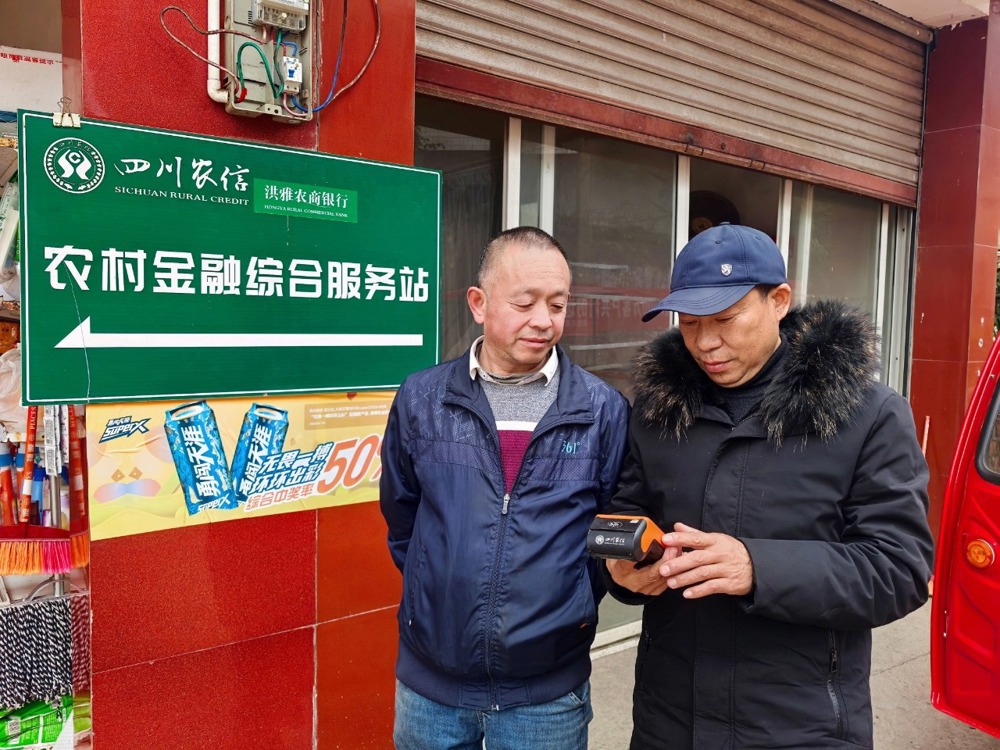 图为站点工作人员正在帮村民办理业务
