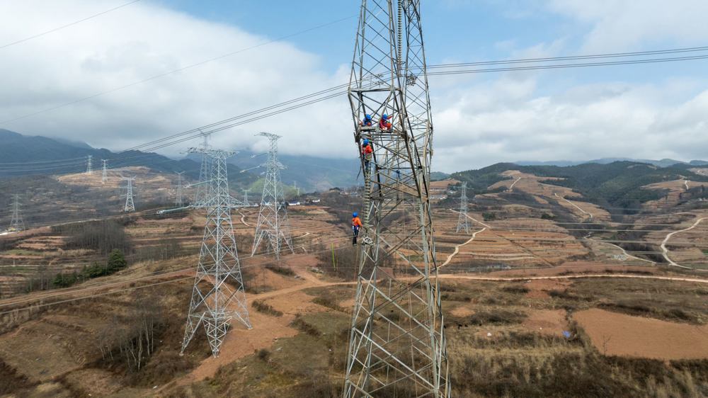 2月20日，在凉山州昭觉县攀西电网优化工程第五阶段施工现场，工作人员正在塔上开展导地线拆除作业。