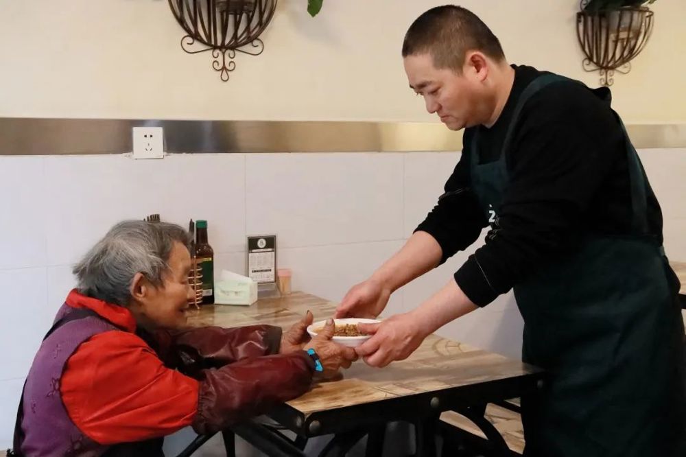 李红为老人端上一碗面