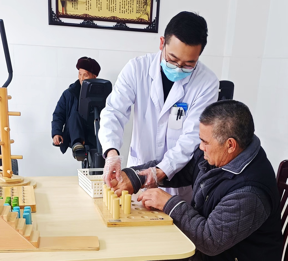 石腊春老人在医护人员的陪伴下进行康复训练1