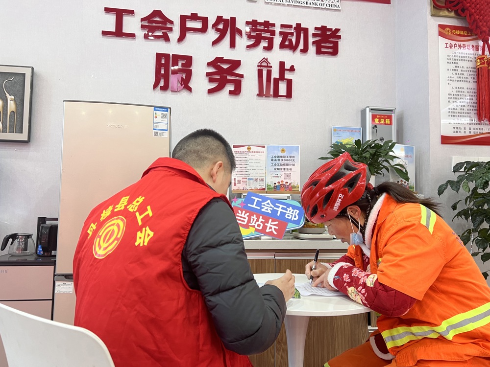 图为工会干部（左）为困难职工讲解政策
