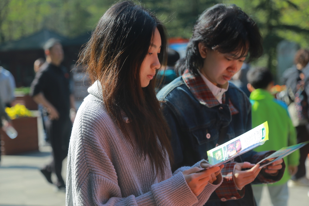 3月23日，成都青城山景区，游客阅读防火宣传单
