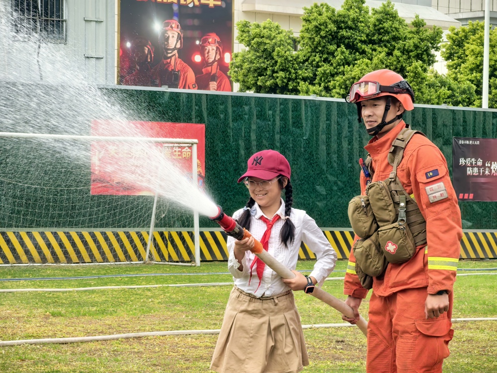 4月11日，在成都市永安路333号总队特勤大队，小朋友体验水枪灭火。