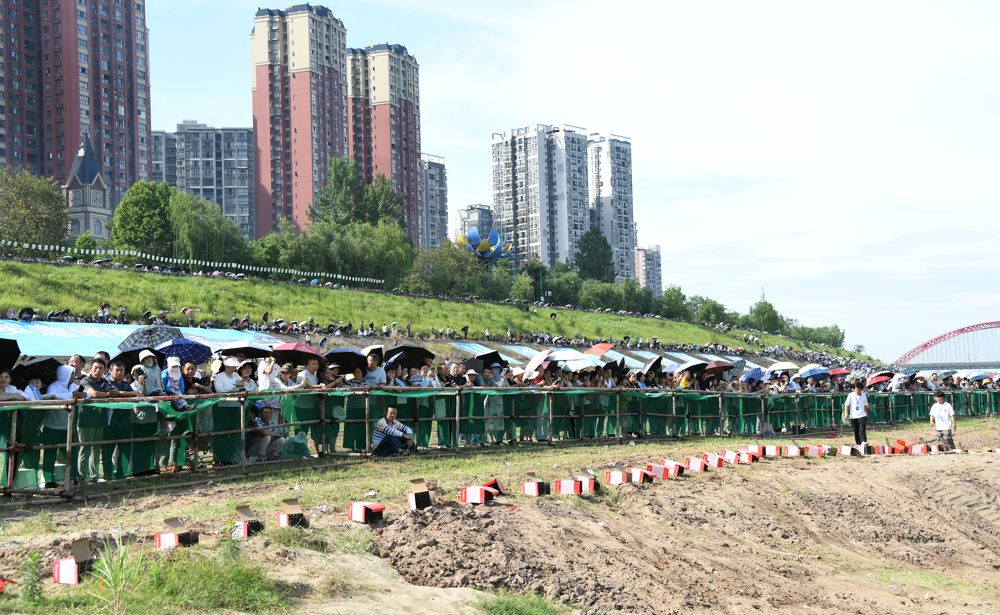 观众们冒着烈日现场观赛为龙舟赛选手加油助威  摄影 王玉杰