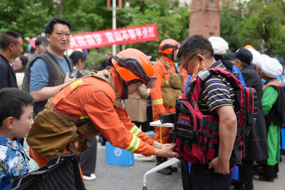 消防员指导现场群众穿救生衣