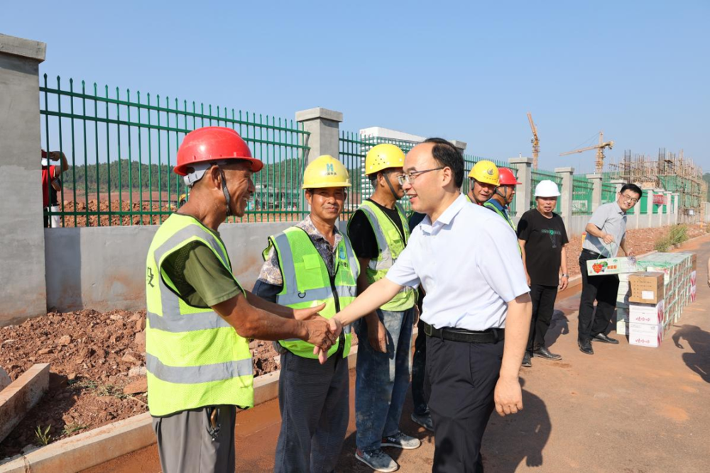 图为县委书记何鹏到项目工地慰问建筑工人