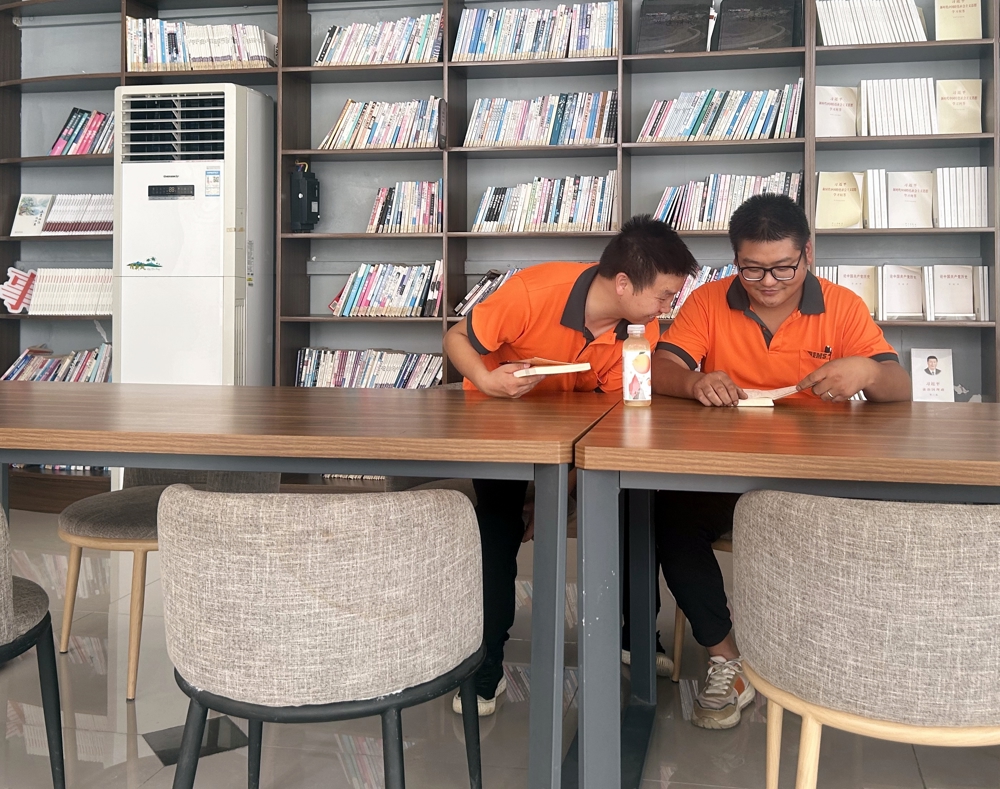 快递员在朝天镇朝闻书社暖新驿站里看书休息