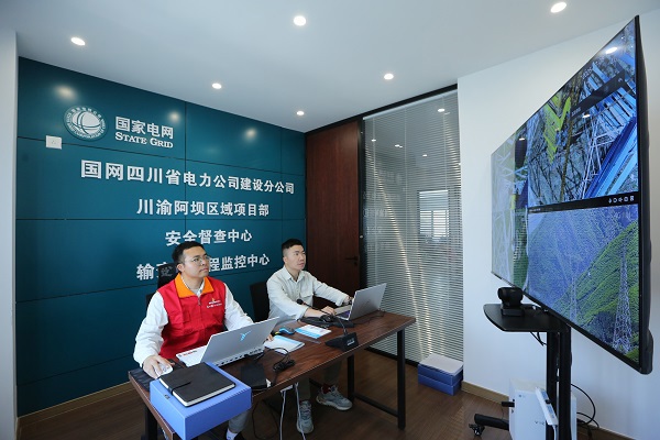 在阿坝—成都东1000千伏特高压交流工程川西段组塔现场，党员突击队队员在输变电远程监控中心查看抱杆摄像头监控画面，进行安全督查。 李萌 摄