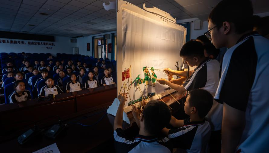 图为学生在演绎皮影戏