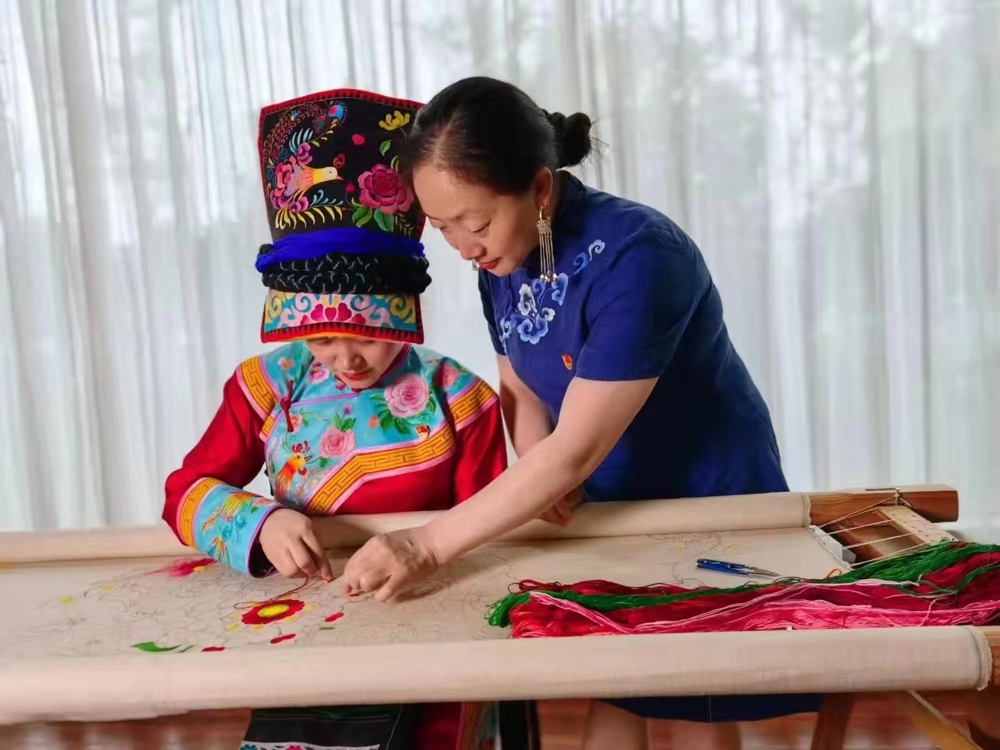 羌绣省级非遗传承人陈云珍手把手指导学员练习羌绣针法