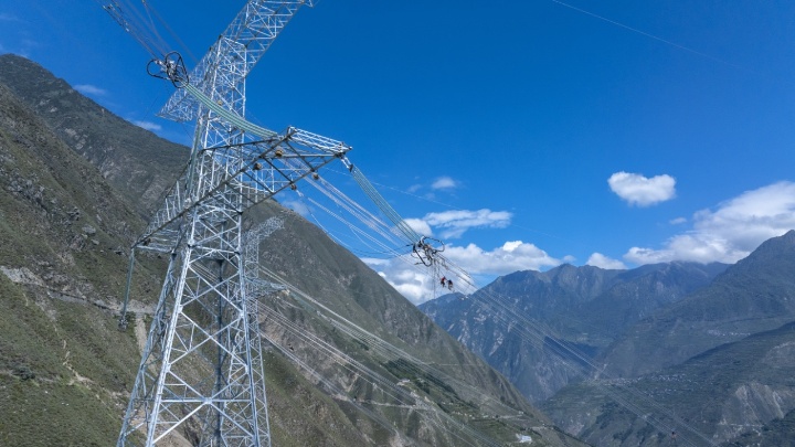在阿坝藏族羌族自治州汶川县，作业人员正在阿坝至成都东1000千伏特高压交流输电工程14大档距跨越现场，开展紧线作业。 谢春艳 摄