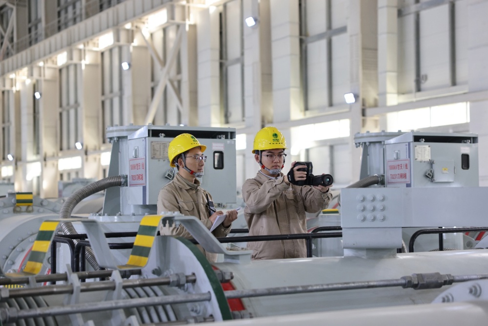 在甘孜1000千伏特高压变电站，运维人员赖俊吉、李轲在1000千伏GIS厂房测温。 李威 摄