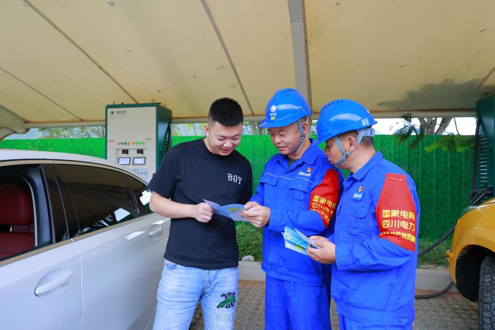 9月30日，国网四川雅安汉源县供电公司员工在汉源记忆公园向正在充电的新能源车主讲解用电安全。 廖亮  摄