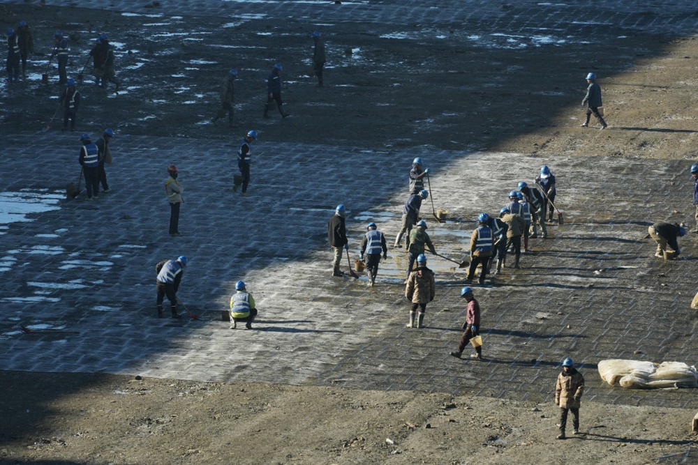 10月28日，在阿坝1000千伏变电站建设现场，作业人员正在清理雪后填方坡区域的积水。