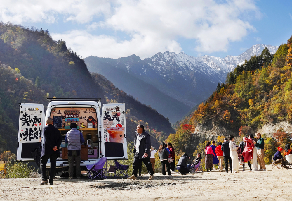 游客在雪山彩林观景台赏景