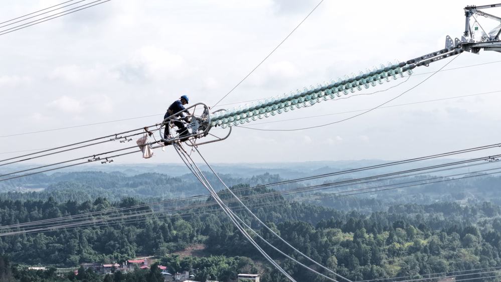 在空港500千伏变电站线路工程现场，电网建设人员进行引流搭接作业。 陈翔 摄