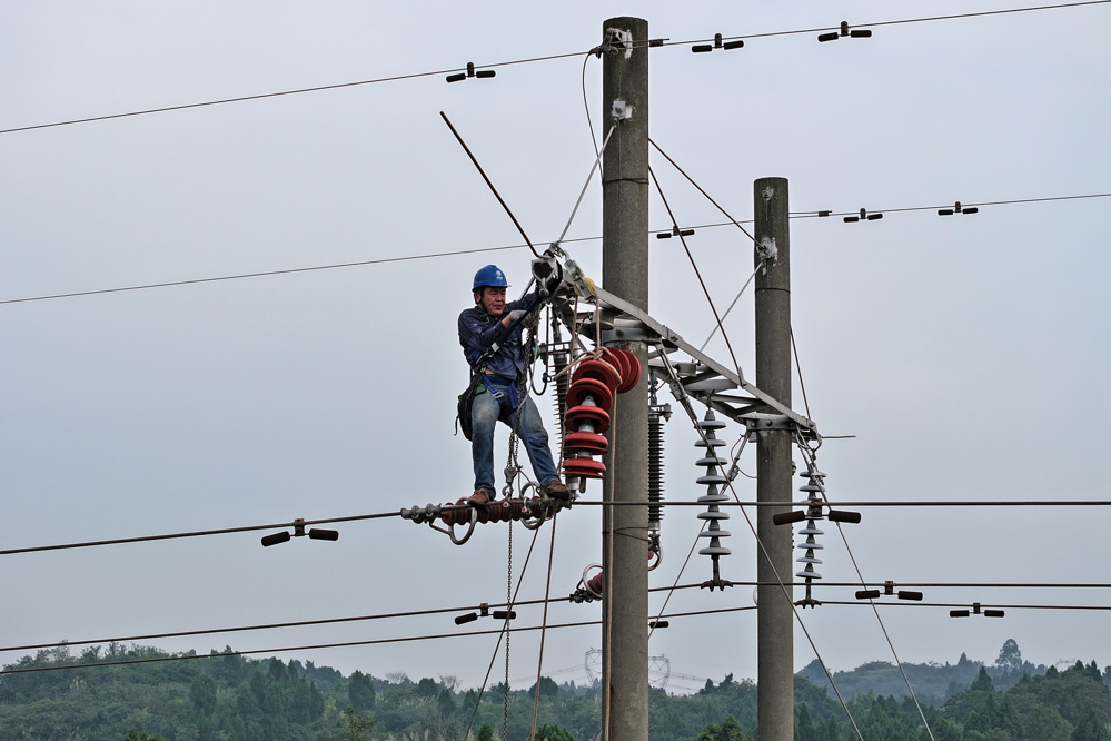 电力工人安装交流盘形悬式瓷复合绝缘子（苟华彬 摄）