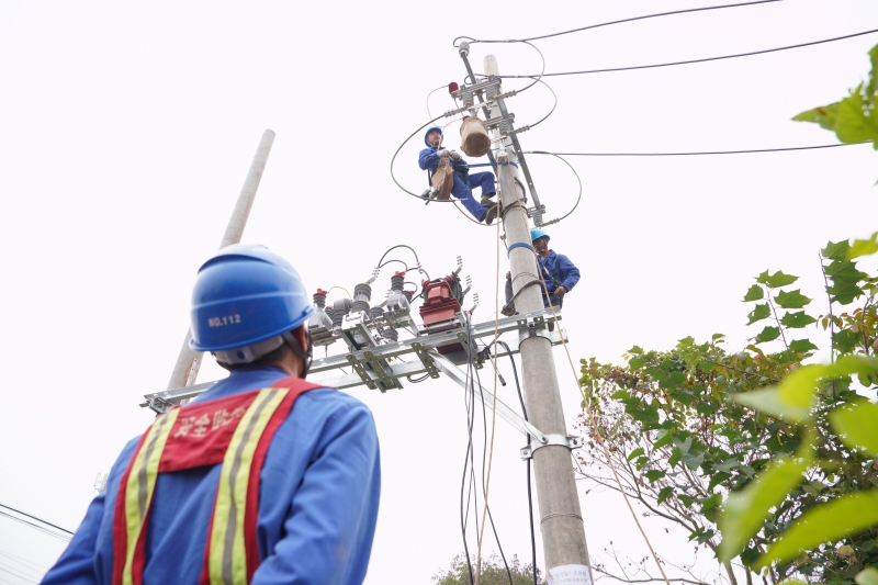 图为电力工人安装农场开关、计量设备（苟华彬 摄）