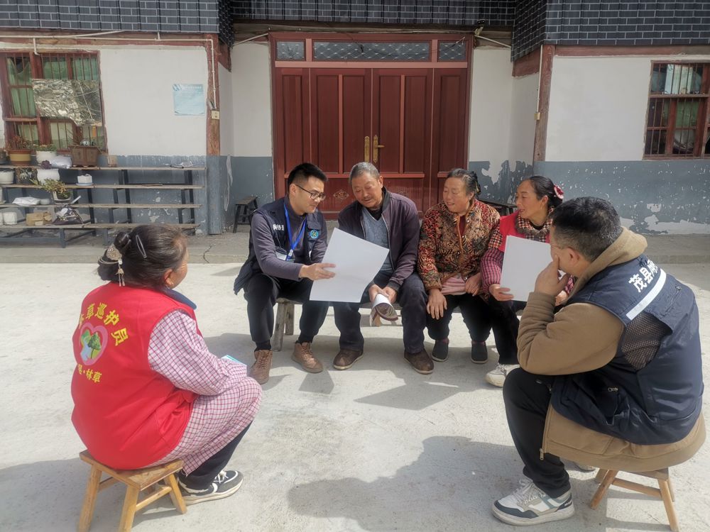 邱政（左二）在坝坝会上宣传森林草原防灭火政策