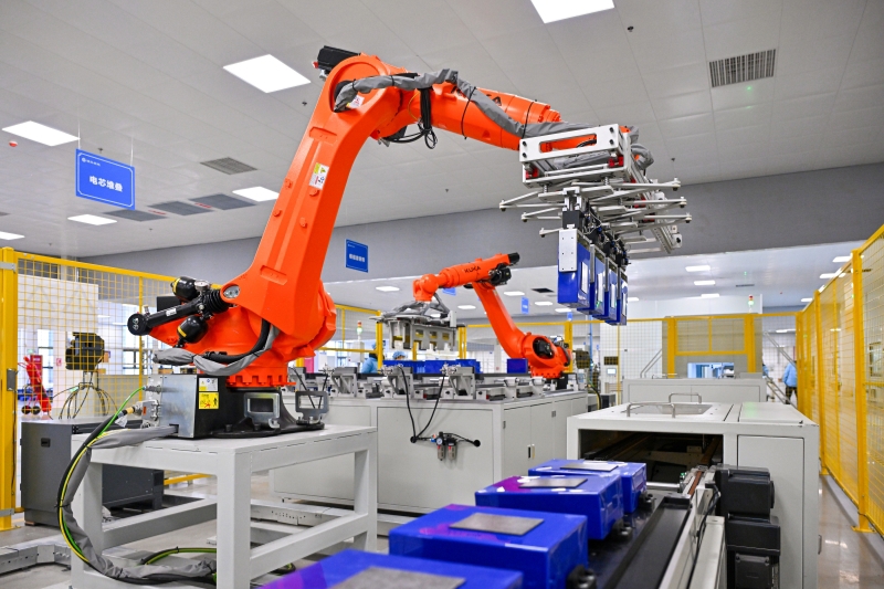 在自动化生产车间,机械臂正在搬运电池模组(潘帅摄)