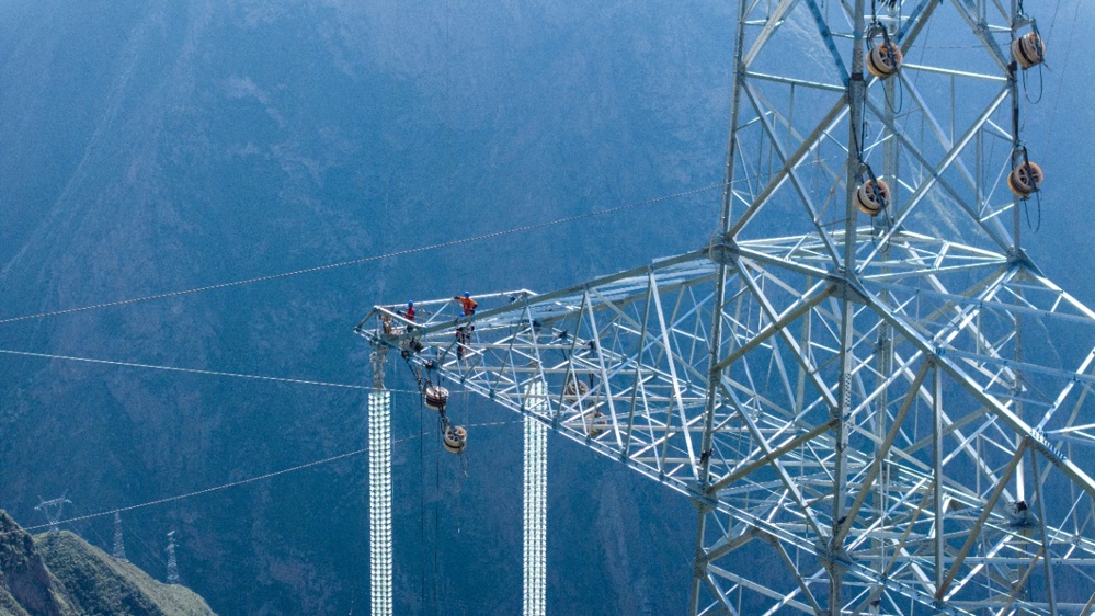 在阿坝—成都东1000千伏特高压交流输电工程现场，作业人员正在开展导引绳展放工作。谢春艳 摄