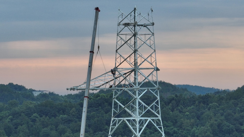 在阿坝—成都东1000千伏特高压交流输电工程现场，作业人员在开展吊装组塔作业。李萌 摄