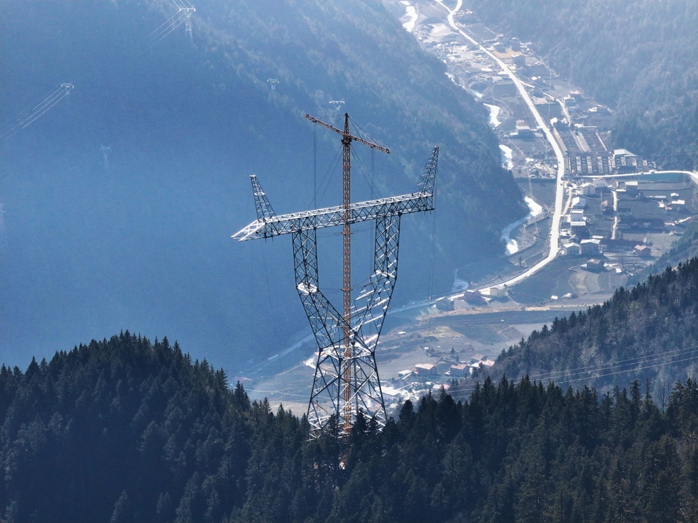 在阿坝州理县米亚罗镇，阿坝—成都东1000千伏特高压交流输电工程1标段正通过双平臂抱杆方式开展组立工作。 尤琅 摄