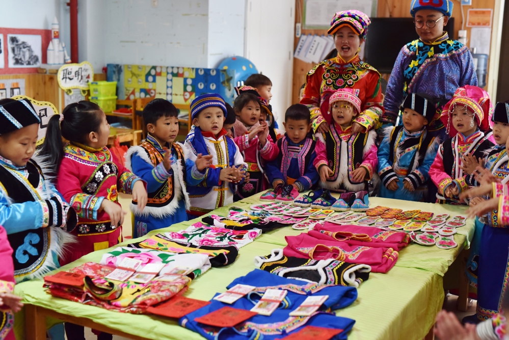 幼儿园老师向孩子们讲解羌绣作品