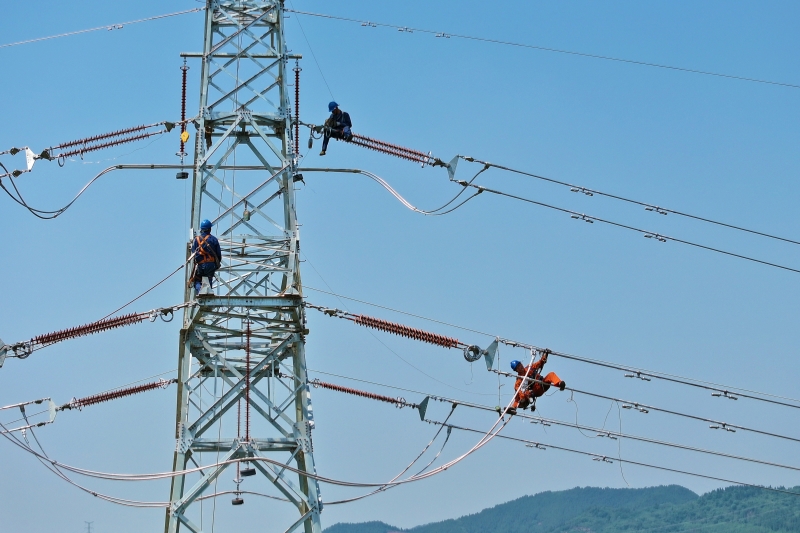 电力工人正在高空开展线路断线作业（苟华彬 摄）