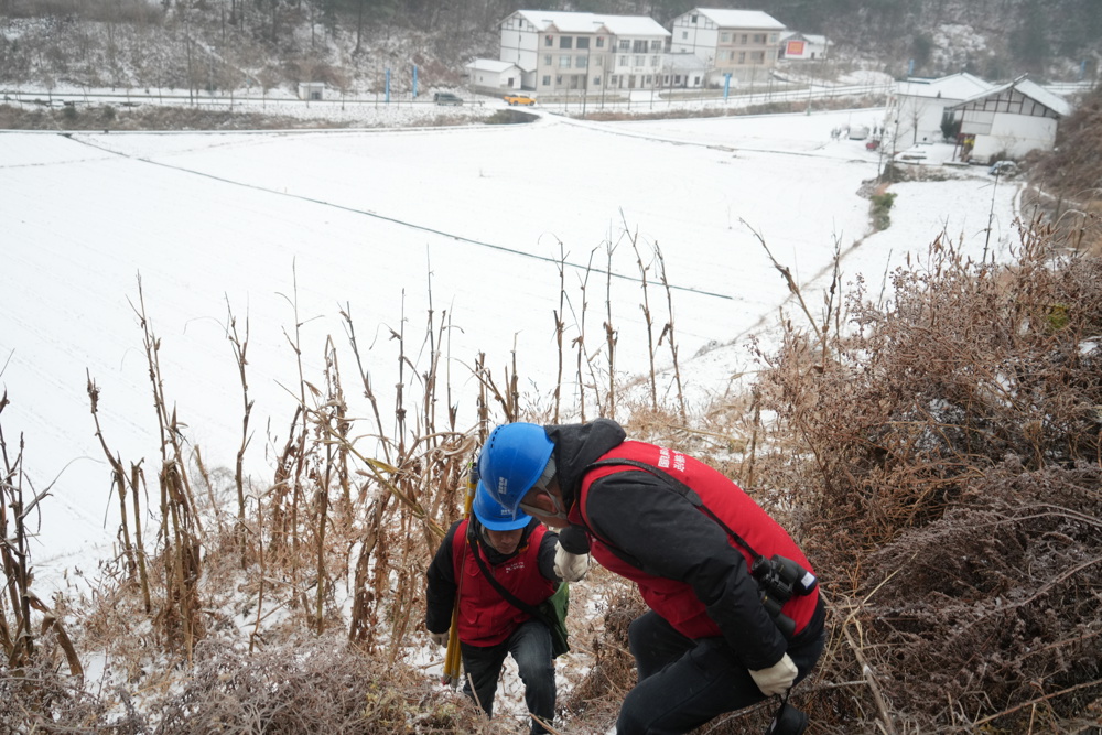 大雪天气，电力工人在巡线的路上