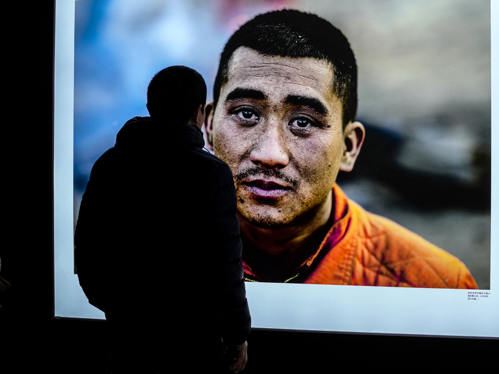 一名游客在消防员面前驻足观赏。 &nbsp;摄影：向文军