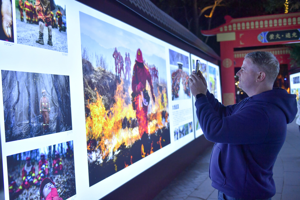 摄影展吸引外籍游客拍摄留念。摄影：李向雨 