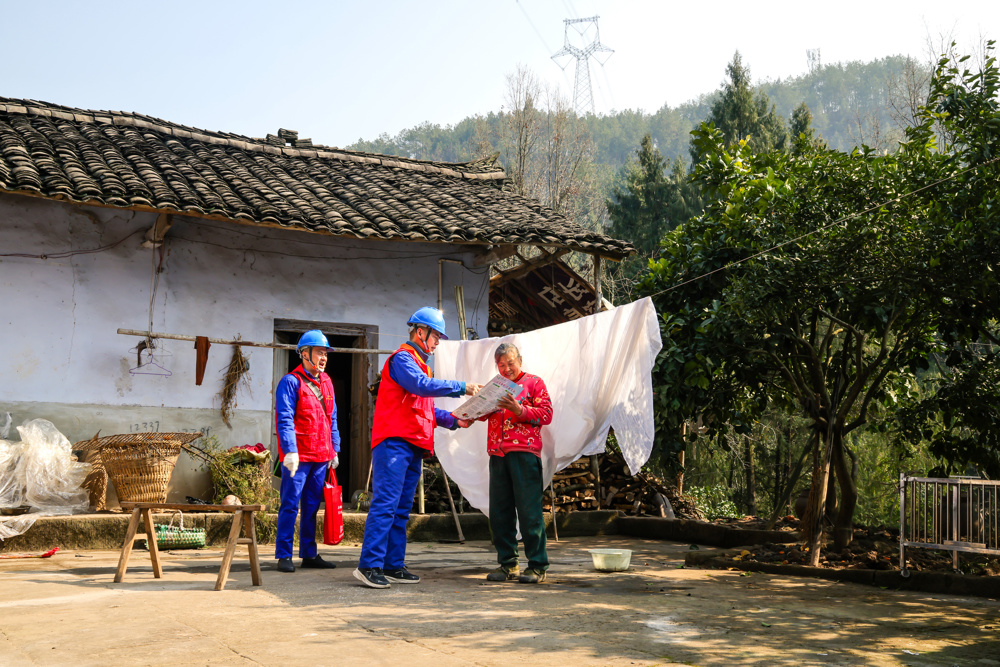 国家电网四川电力（巴中）连心桥共产党员服务队队员在巴州区光辉乡白鹤山村三社为客户检查线路，讲解春节安全用电知识。 王志刚 摄