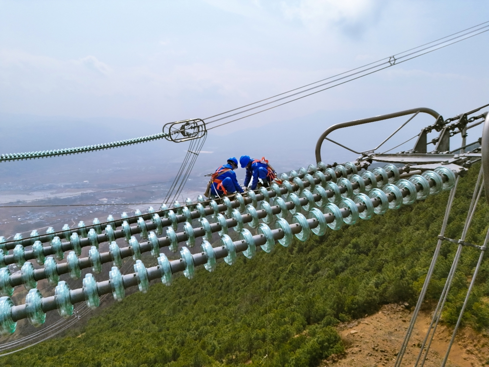 国网四川超高压公司检修人员正在为白鹤滩—江苏±800千伏特高压工程输电线路更换自爆绝缘子。 罗伍达 摄