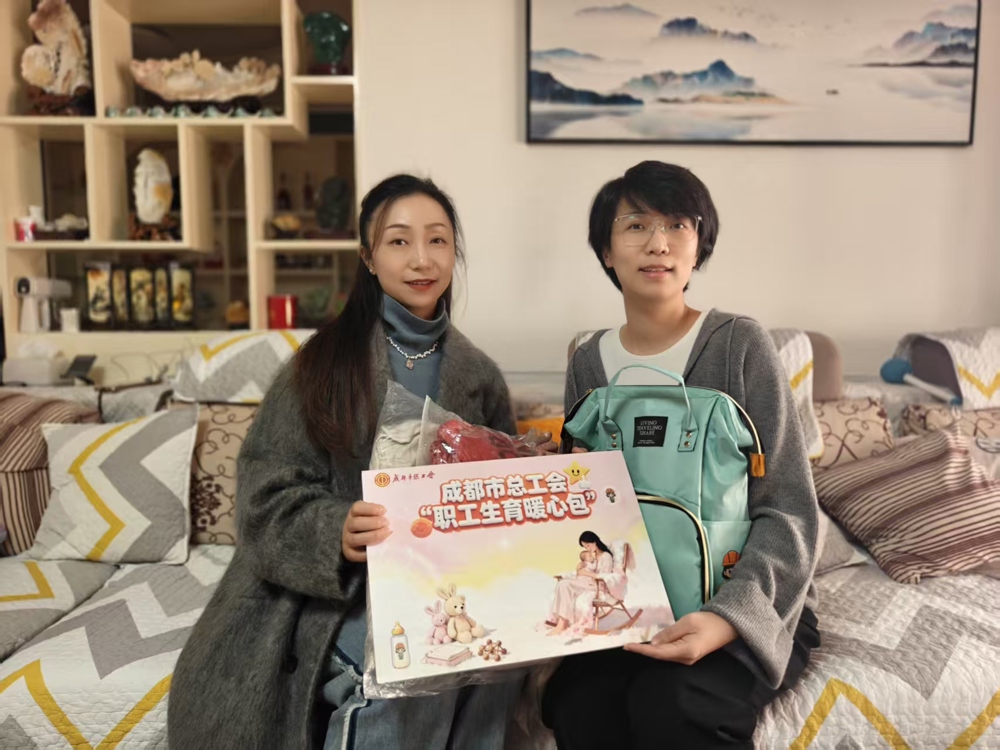 女职工郑恒煊（右）收到工会“生育暖心包”
