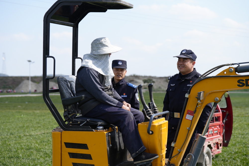 刘营派出所副所长陈彦在麦冬地里与采收工人讲解反诈知识