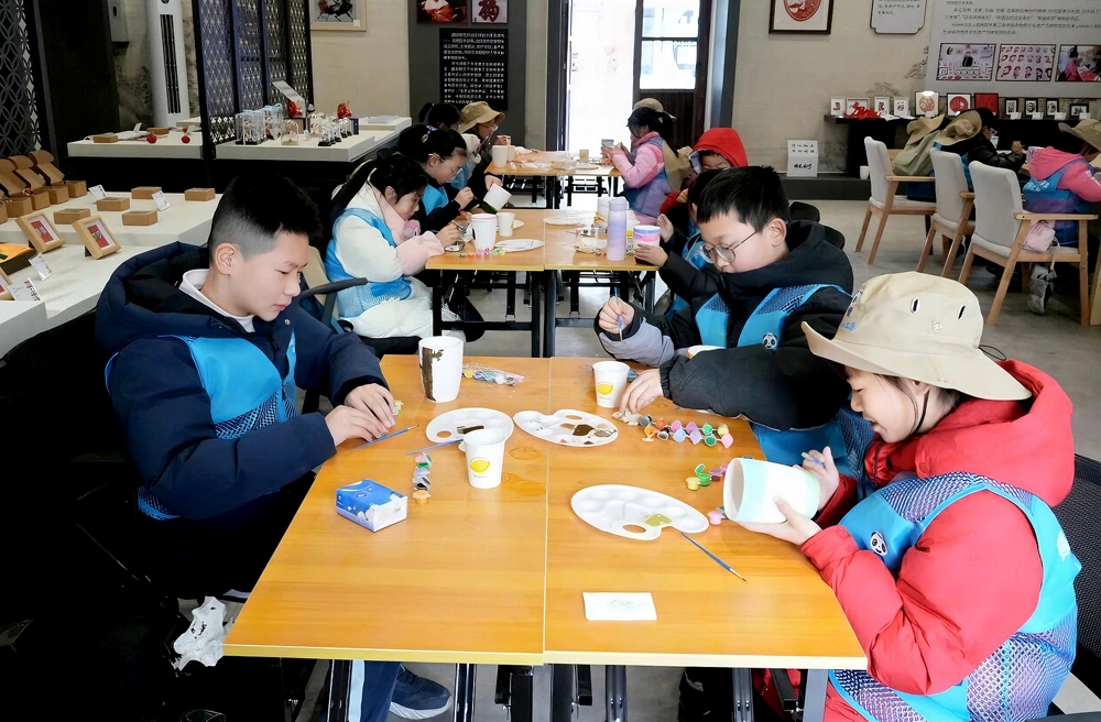 学生在非遗龙州体验陶罐彩绘