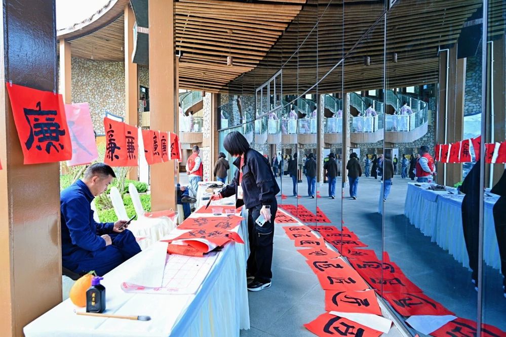 职工在红色宣纸上书写“廉”字与“匠”字