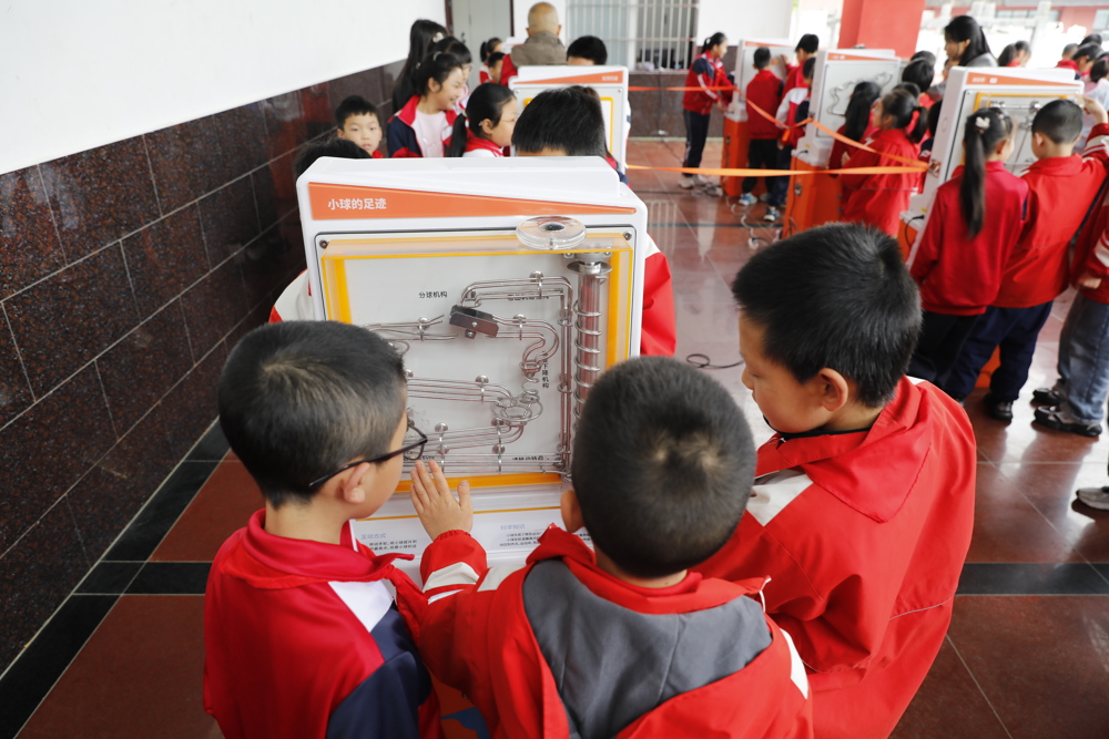 孩子们围着科普仪器探索科学奥秘