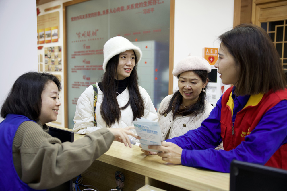 ，图为社区、电网工作人员共同为居民讲解一户多人口用电优惠政策。 黄盛 摄