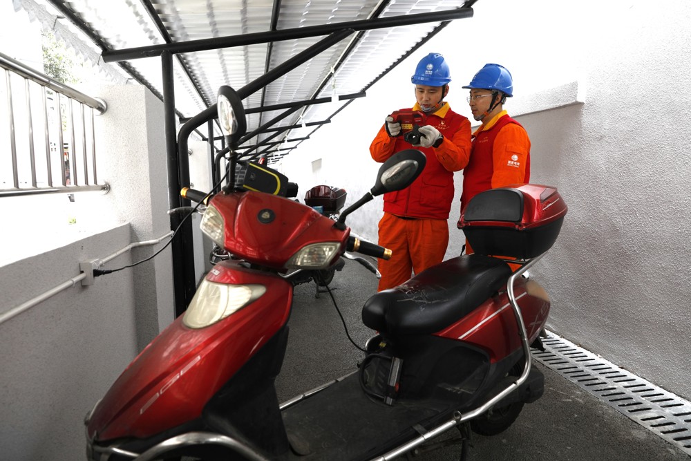 国网四川电力成都高新连心桥党员服务队队员在玉林西路31号院开展电瓶车充电安全测试。 陈红梅 摄