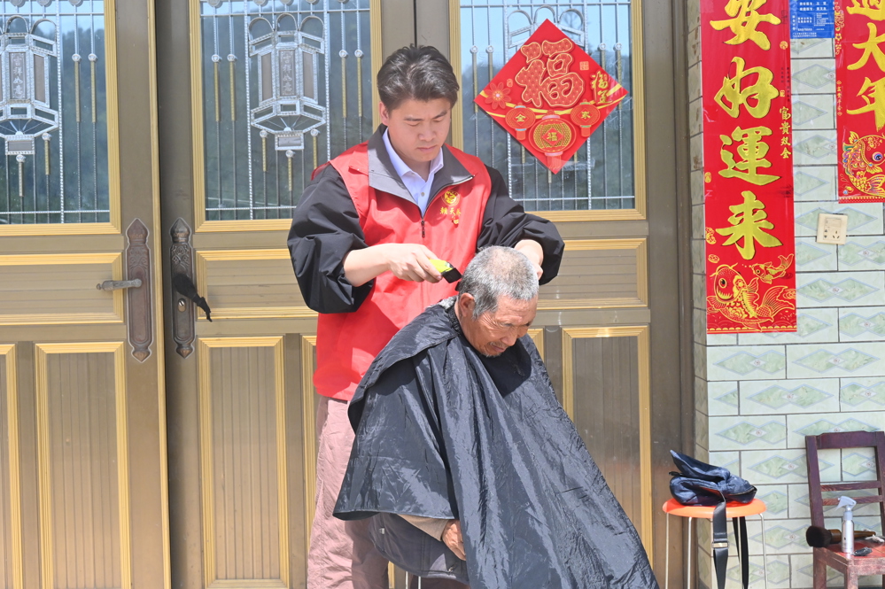 志愿者为老人修剪头发