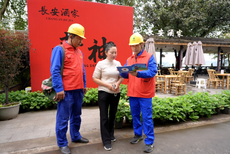 服务队队员向景区餐饮经营者宣传安全用电知识（敖洋摄）