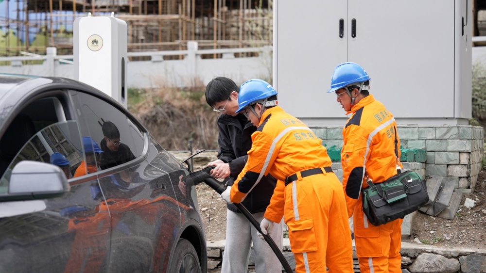 在四姑娘山景区游客充电站，国网四川阿坝供电公司四姑娘山供电服务站逐台巡检充电桩运行状态，耐心解答新能源车主的充电疑问。 张懿玲 摄