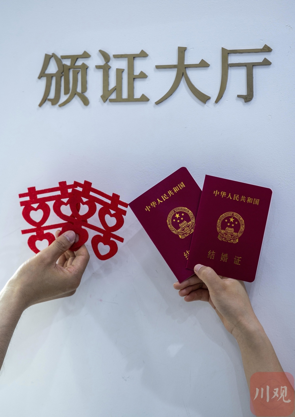 新人在婚姻登记处手拿结婚证留影纪念。资料图