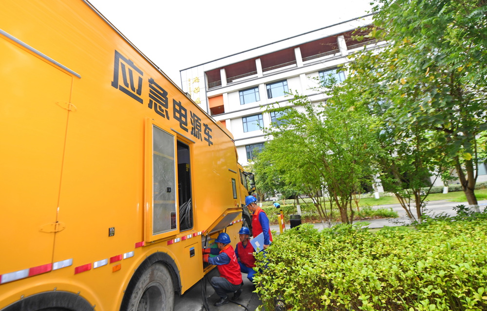 6月7日，在简阳市高考考点石室阳安中学保电现场，电力员工对应急发电车接入电源进行检查。 陈翔 摄
